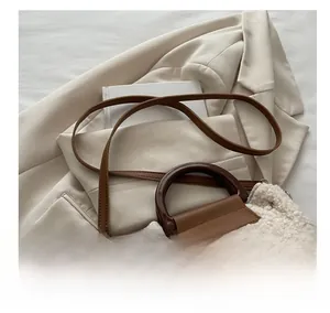 Detail of shearling small square bag with brown resin ring handle and leather strap