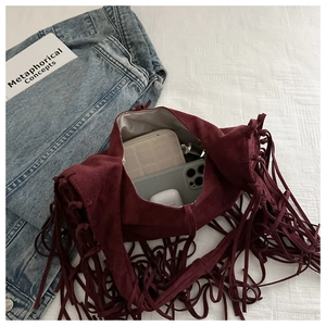 Internal view of burgundy suede tassel shoulder bag showing spacious storage for daily items