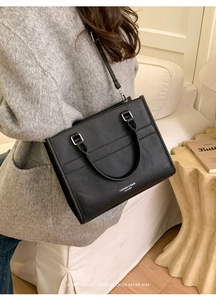 Elegante borsa tote in pelle nera a tracolla in un ambiente interno accogliente