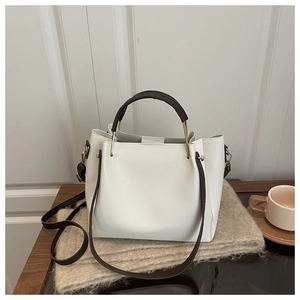 Detail of white lychee pattern tote with dark brown handles on soft fabric