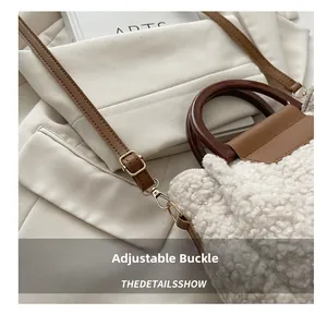 Gros plan sur la texture en peluche blanche avec bandoulière en cuir brun et boucle dorée