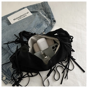 Detail of black tassel shoulder bag interior showing capacity for phone and wallet