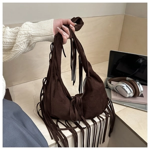 Detail of dark brown suede crescent bag featuring long fringe and bohemian styling