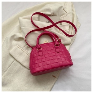 Detalle del bolso fucsia con relieve de tablero y elegantes herrajes metálicos dorados