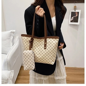 Détail du sac cabas beige à motif d'étoiles porté par un mannequin dans un salon chic