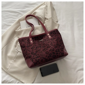 Detail of burgundy leopard print tote bag with reinforced leather trim and gold studs
