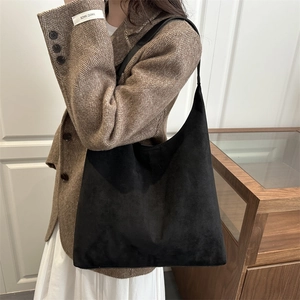 Grand sac cabas noir mat porté par un mannequin dans un décor intérieur épuré