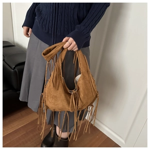 Close-up of caramel brown suede hobo bag with long tassels and bohemian fringe details