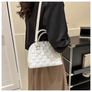Detail der weißen halbkreisförmigen Handtasche mit Gitterprägung und Goldreißverschluss