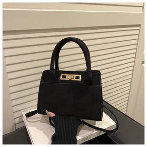 Détail du sac à main vintage noir mat avec fermoir rotatif doré et doubles poignées