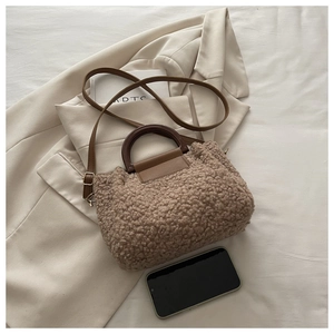 Brown teddy fleece bucket bag shown with a smartphone to demonstrate the actual product size