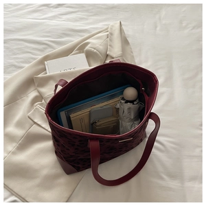 Detail of burgundy leopard tote bag interior capacity with books and essentials