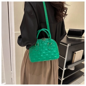 Detalle de bolso acolchado verde lima con herrajes dorados en una escena de estilo de vida