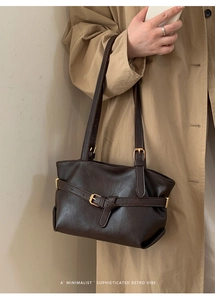 Borsa a spalla retrò marrone scuro indossata con trench beige per un look di classe