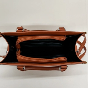 Brown leather handbag with large capacity three-compartment interior and silver metal hardware