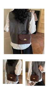 Detail of dark brown quilted suede handbag with gold lock and chain strap on a model