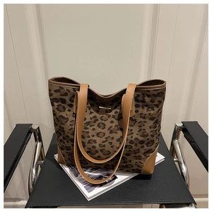 Detailed close-up of large leopard print tote bag on a black leather chair decoration
