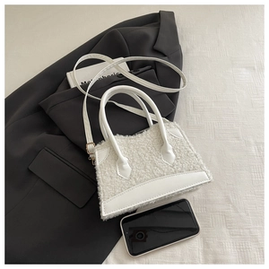 Gros plan détaillé d'un sac à main blanc en fausse fourrure avec finitions en cuir