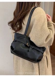Dettaglio borsa a spalla retrò nera con fibbia metallica su cappotto in tweed