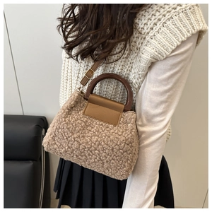 Détail de la texture polaire teddy avec poignée en résine et bandoulière en cuir du sac