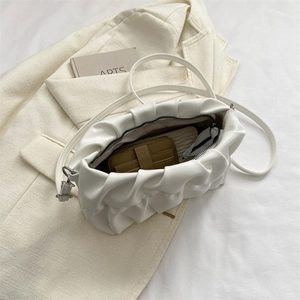 Chic off-white pleated cloud bag with slim shoulder strap on elegant suit fabric