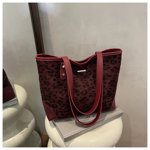Detail of leopard print suede and red leather patchwork tote bag with gold metal trim