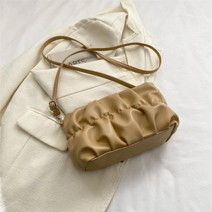 Chic pleated cloud shoulder bag in khaki faux leather on minimalist background
