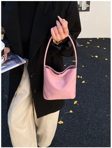 Dettaglio della borsa in nylon rosa con ricamo su sfondo di foglie di ginkgo gialle