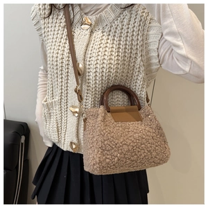 Détail du sac seau marron en fausse fourrure avec poignée en bois et bandoulière en cuir