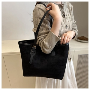 Detail of black suede tote bag showing the fine texture and adjustable golden metal buckle