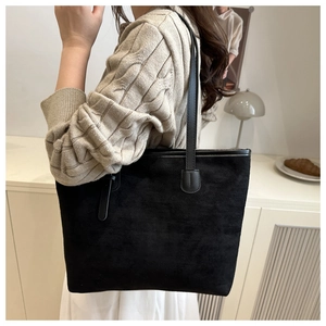 Minimalist black tote bag in matte finish styled in a warm home lifestyle setting