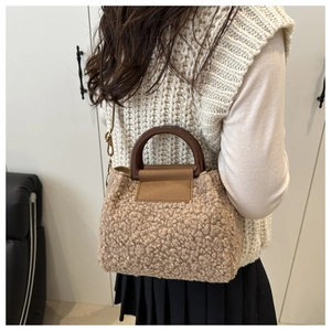 Detail of plush leopard print handbag with resin ring handle and metal strap buckle