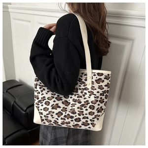 Detail of stylish leopard print tote bag with cream leather trim and spacious design