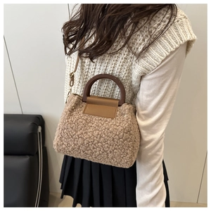 Close-up of curly lamb wool crossbody bag with brown resin handles and leather flap detail