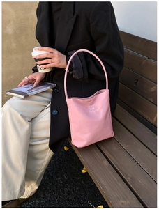 Detailed close-up of pink bucket tote bag with Hope and future print on a wooden bench