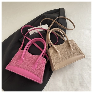 Détail de sacs à main en peluche rose et beige avec anses en cuir et garniture dorée