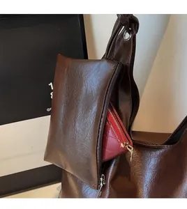Detail of dark brown tote bag with a functional detachable zippered charm pouch