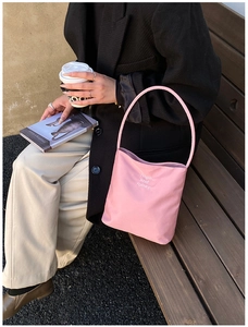 Close-up of pink canvas tote bag with Hope and future embroidery in outdoor street setting