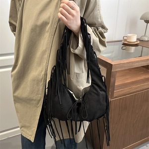 Black suede crescent moon hobo bag with long fringe tassels and wide shoulder strap