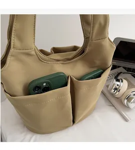 Détail du sac cabas kaki avec deux poches avant pratiques et tissu très résistant