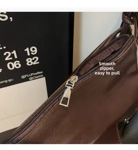 Macro detail of smooth silver metal zipper on vintage brown leather tote bag texture