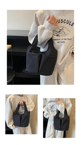 Détail du sac seau en nylon noir avec deux poches avant ouvertes fonctionnelles