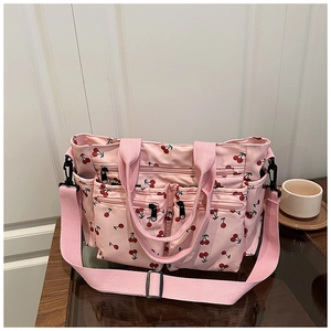 Détails du sac fourre-tout rose avec motif cerise, multiples poches et larges anses