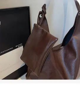 Detail view of brown large tote bag in glossy PU leather with a detachable small pouch