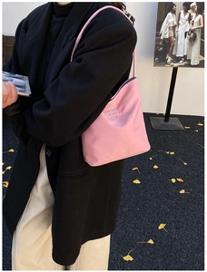 Detalle de bolso tipo saco rosa con bordado hope and future en un entorno exterior