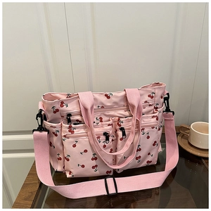 Détail du sac fourre-tout rose à motif cerises avec poches et poignées robustes