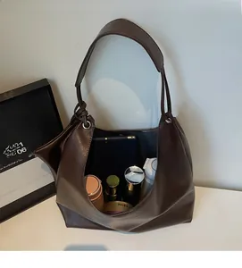 Spacious interior of a dark brown large tote bag showing tablet and cosmetics storage