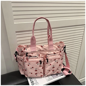 Détail du sac cabas rose imprimé cerise avec poches zippées avant et poignées souples