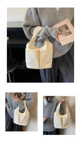 Détail du sac cabas en nylon ivoire avec deux poches avant et poignée au design minimaliste