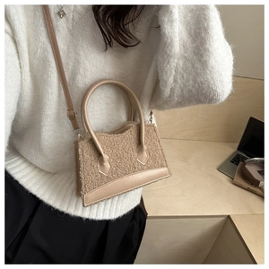 Close-up of plush lamb wool square bag with premium leather handles and metal hardware